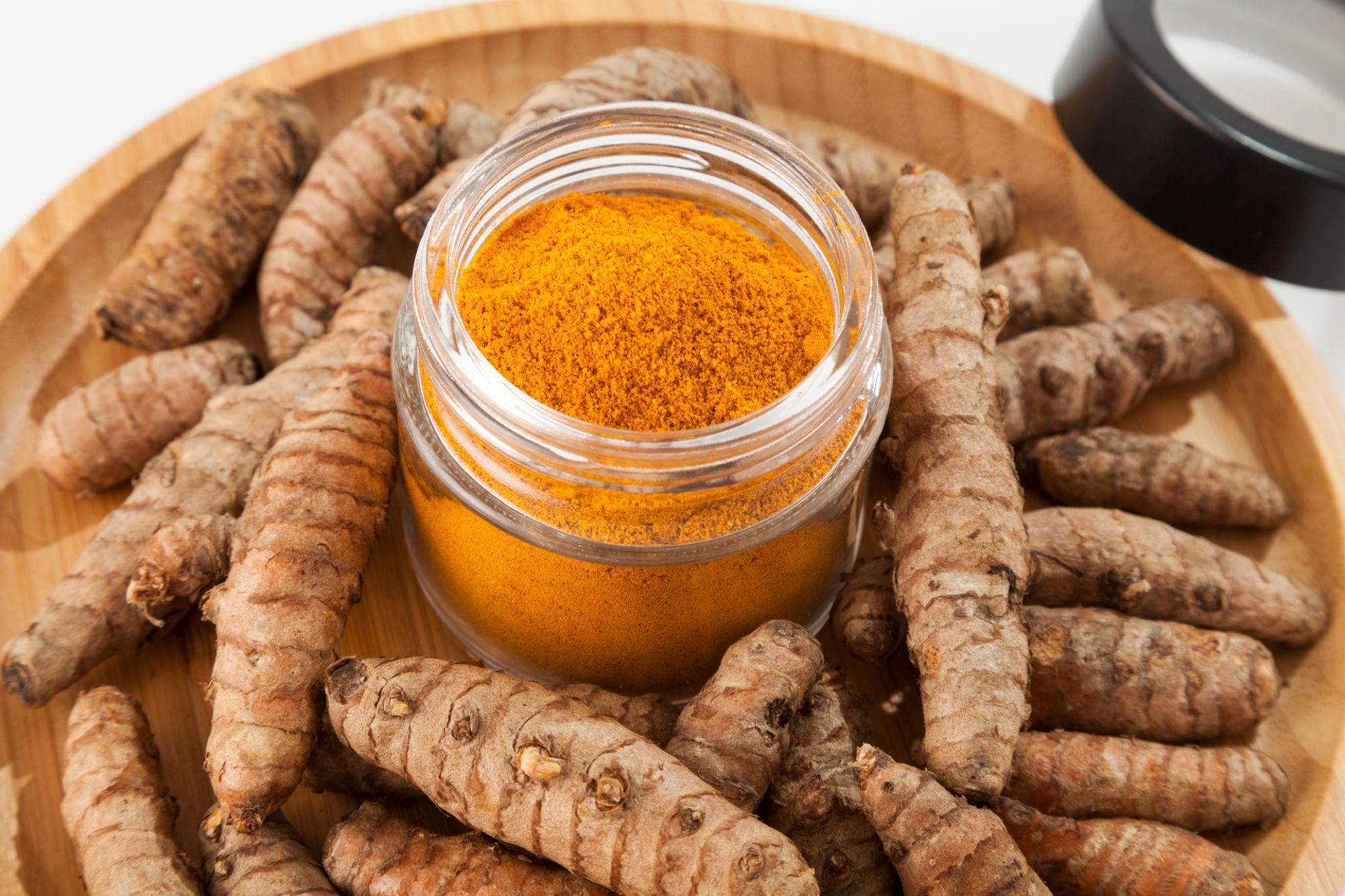 Pure turmeric powder and whole turmeric roots showing natural color and freshness